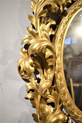 Grande specchiera ovale scolpita e dorata